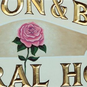hand painted rose on carved sign